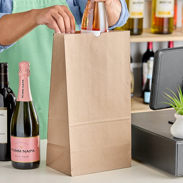 A person pouring bottles into a Choice natural kraft paper bag.