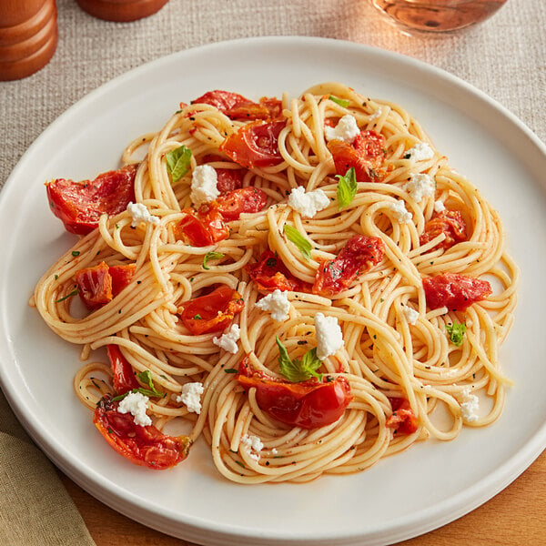 A plate of pasta with Sevillo Slow Roasted Red Tomatoes and feta cheese.