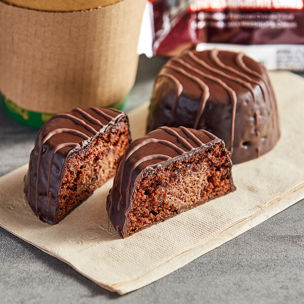 A Mrs. Freshley's HERSHEY'S Triple Chocolate cake with a bite taken out of it on a napkin.