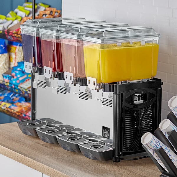 A Carnival King refrigerated beverage dispenser with containers of red, yellow, and blue liquid.