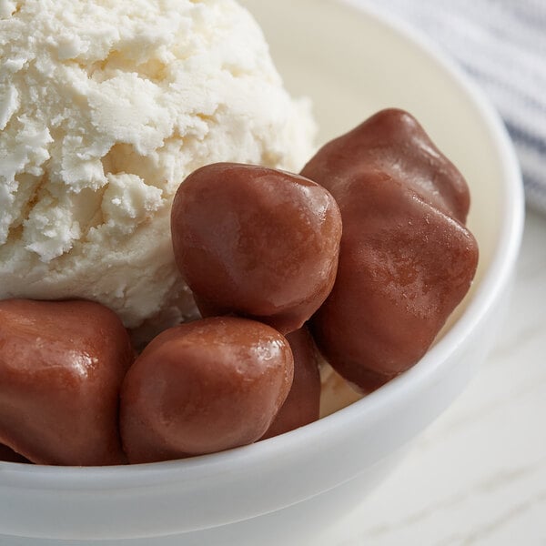 A bowl of ice cream with TruFru chocolate-covered strawberries.