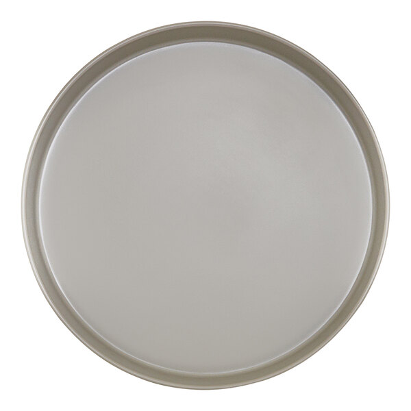 A close-up of a white Cal-Mil melamine plate with a raised rim and a white circle.