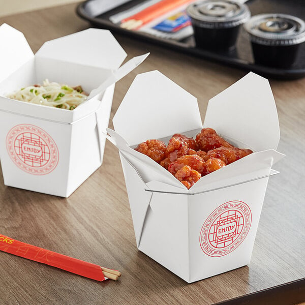 Two Emperor's Select Chinese take-out containers filled with food on a table.