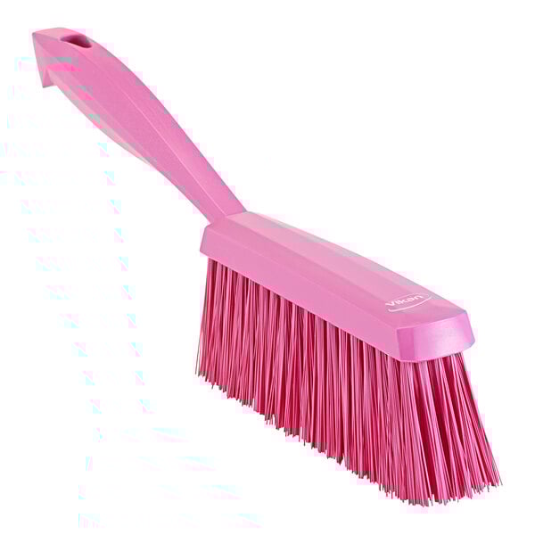 A pink medium hand brush with a long handle.