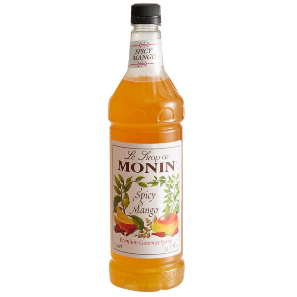 A bottle of Monin Spicy Mango flavoring syrup with an orange label.