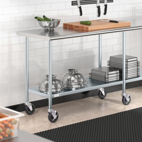 A Steelton stainless steel work table with undershelf and casters holding a cutting board and bowls.
