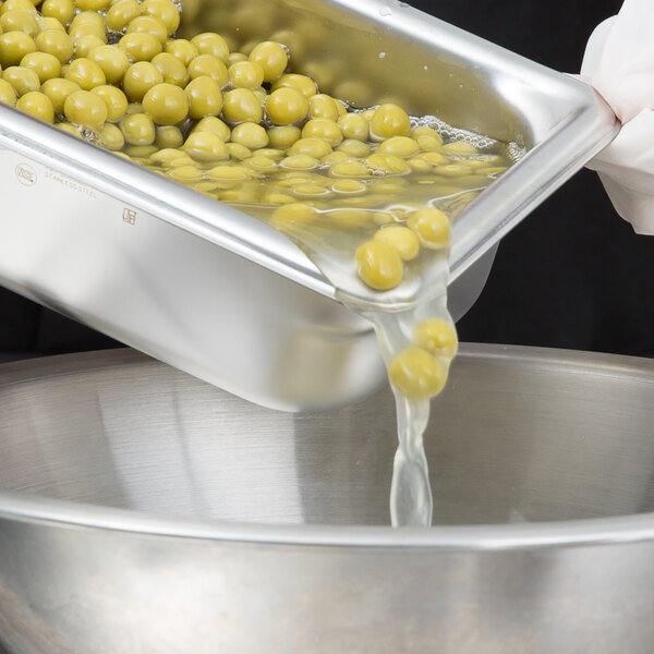 A metal tray with Sweet Peas being poured into it.
