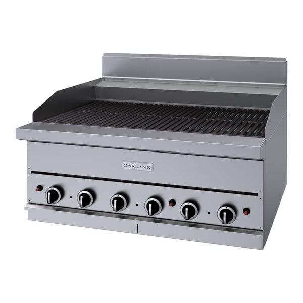 A stainless steel Garland liquid propane charbroiler with knobs over a grill.