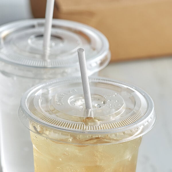 Two plastic cups with Aardvark white unwrapped paper straws in them.