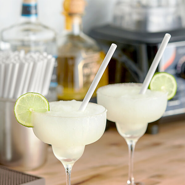 Two drinks with Aardvark giant white paper straws on a table.