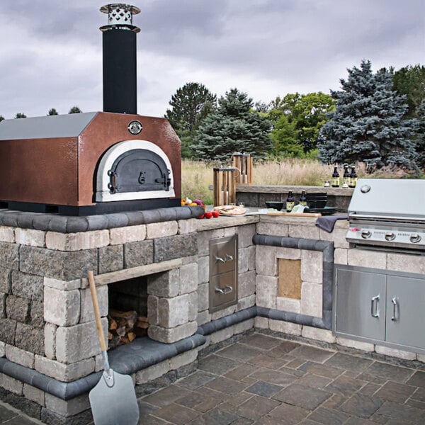 A Chicago Brick Oven countertop pizza oven with a copper vein finish on a patio.
