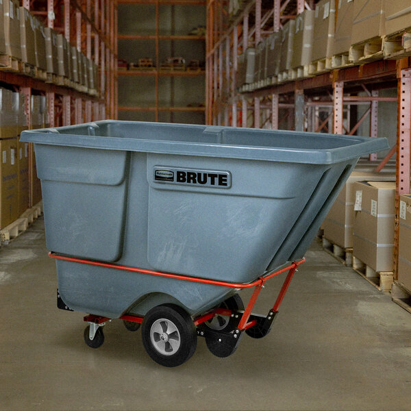 A Rubbermaid gray tilt truck with a large grey container on a black and red cart.