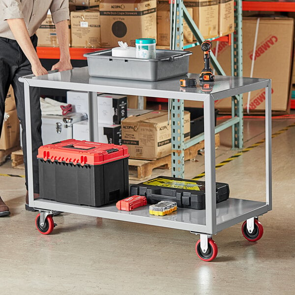 A man standing next to a Lavex steel utility cart with tools on it.