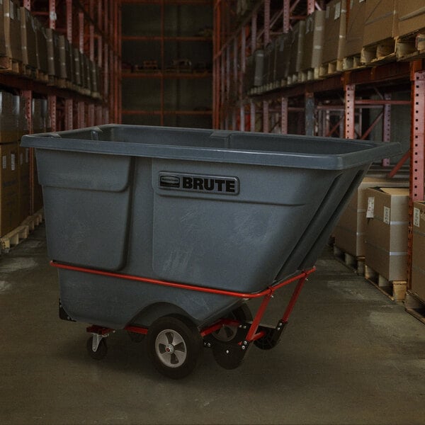 A large grey Rubbermaid tilt truck with wheels in a warehouse.