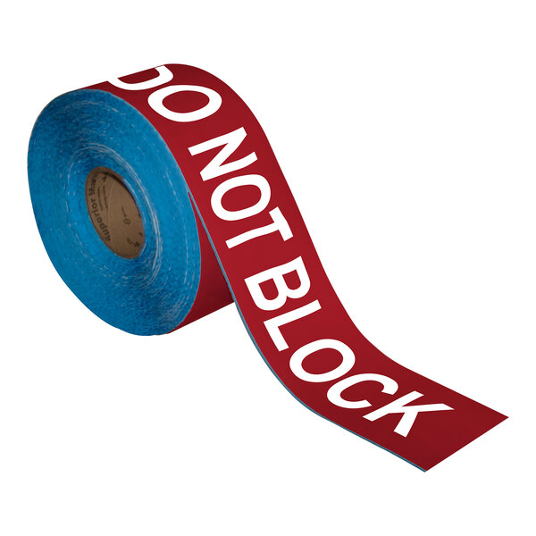 A roll of red and white Superior Mark safety tape with the words "Do Not Block" in white.