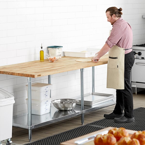 A man in an apron stands next to a Regency wood top work table.