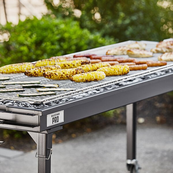 A Backyard Pro heavy-duty steel charcoal grill with corn and sausages on it.