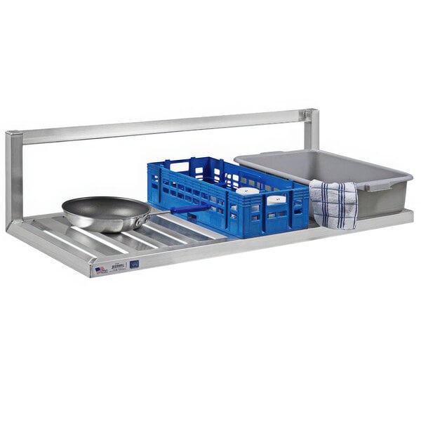 A New Age aluminum T-bar wall shelf with inverted brackets holding pans.
