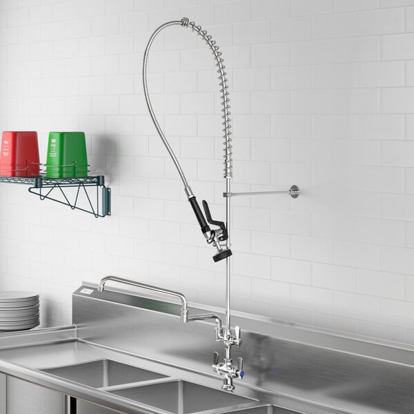 A stainless steel sink with a Regency pre-rinse faucet and double-jointed add-on faucet hose.