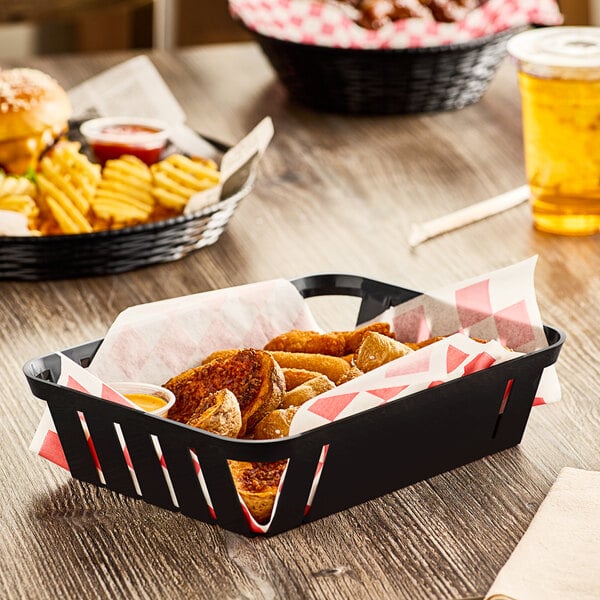 A Carlisle black munchie basket filled with food on a table.