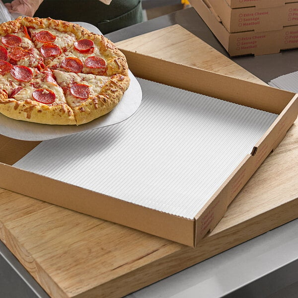 pizza being slid off paddle into box