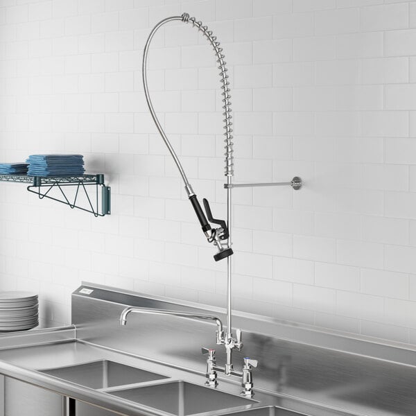 A stainless steel sink with a Regency pre-rinse faucet and hose.