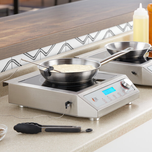 A Cooking Performance Group countertop induction range with two pots on it.