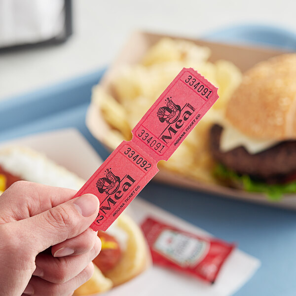 A hand holding a red 1-part meal raffle ticket.