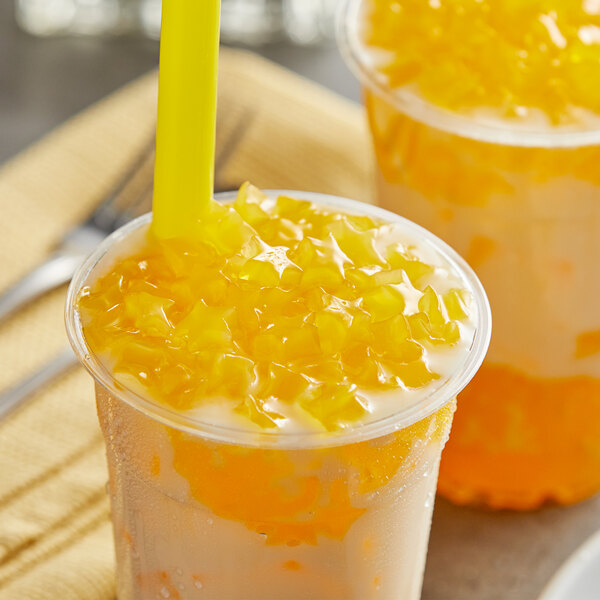 A cup of orange juice with a straw and orange jelly topped with Fanale Mango Star-Shaped Jelly.