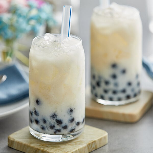 A glass of ice with a straw in it.