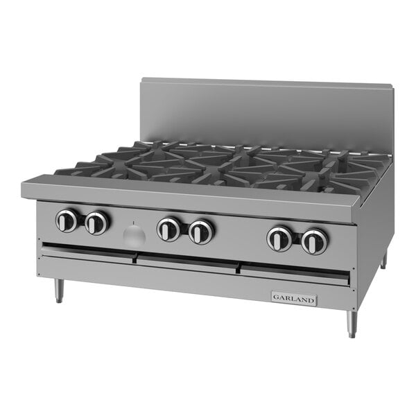 A stainless steel commercial 6-burner gas range top with control knobs and a backsplash.