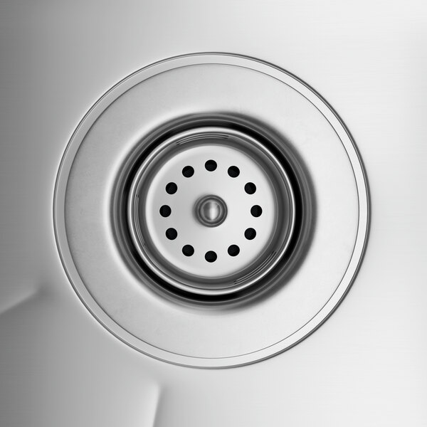 A close-up of a Regency stainless steel underbar sink drain.