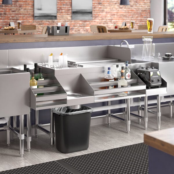 A Regency stainless steel cocktail station with a liquor display rack and cold plate on a counter.