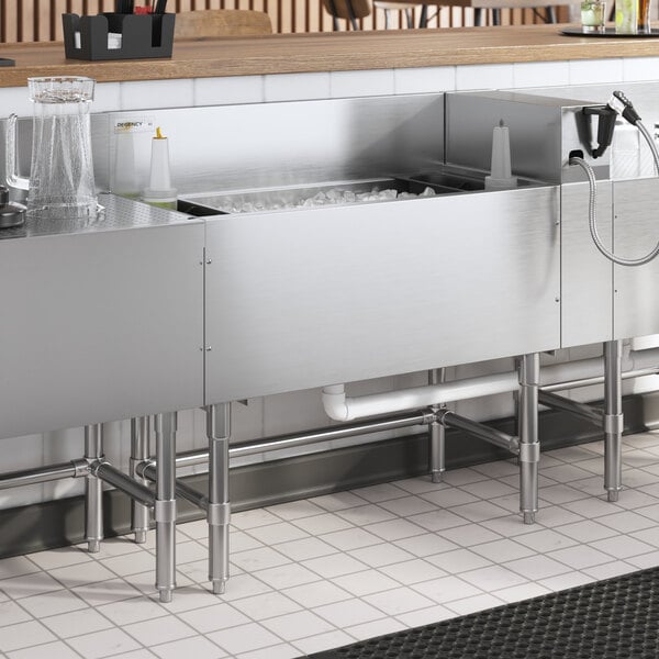 A Regency stainless steel underbar ice bin with bottle holders and a cold plate filled with ice.