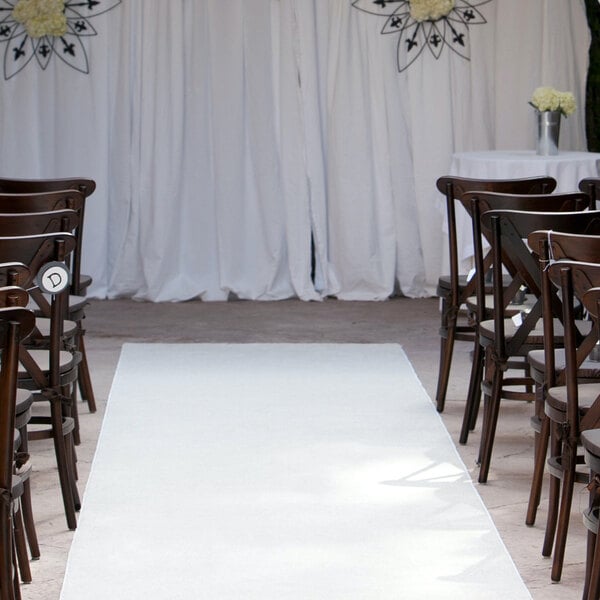 A white FloorEXP carpet runner leading to a wedding ceremony with chairs.