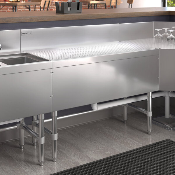 A Regency stainless steel underbar drainboard with a sink and faucet.