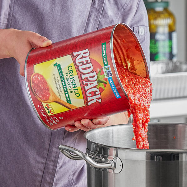 A man pouring RedPack crushed tomatoes from a #10 can.