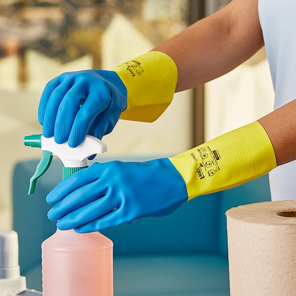 A person wearing blue neoprene gloves over yellow latex gloves.