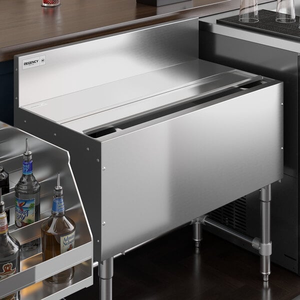 A Regency stainless steel sliding lid on an underbar ice bin.