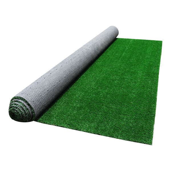 A large roll of synthetic grass partially unrolled on a flat surface.