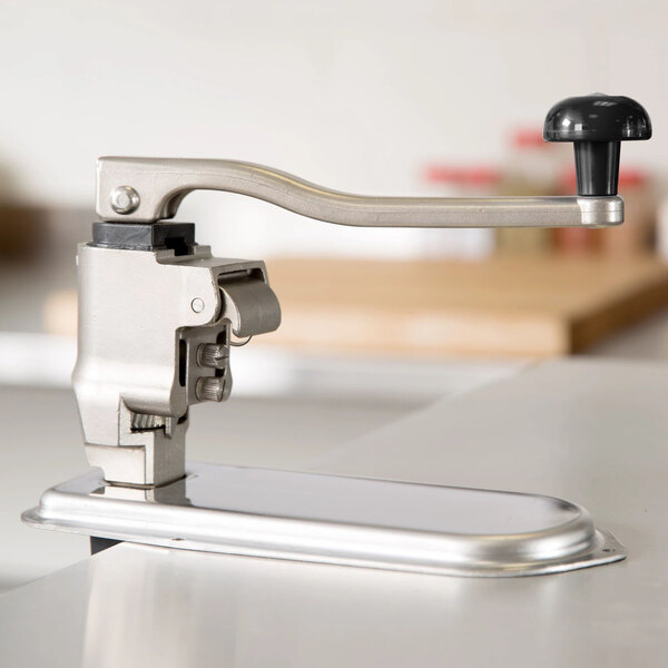 A heavy-duty commercial can opener with a long handle and sturdy metal construction, mounted on a countertop.