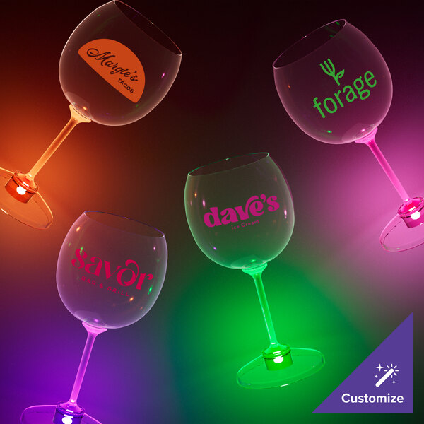 A group of customizable plastic goblets with orange LED lights on a table.