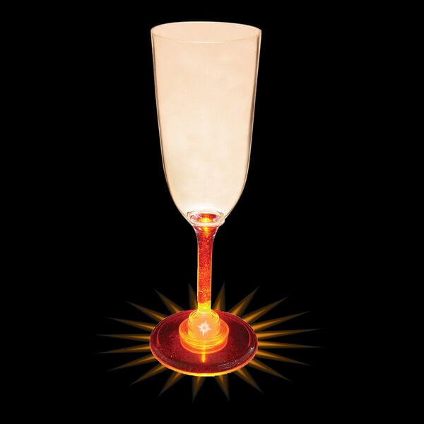 A close-up of a 7 oz. plastic champagne cup with an orange LED light on it.