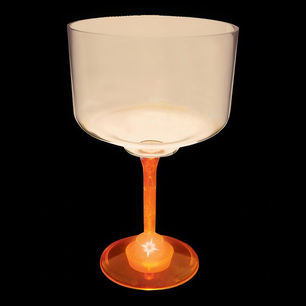 A clear plastic margarita cup with an orange LED light on a black background.