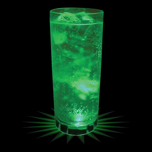 A customizable plastic cup with green LED lights filled with a green drink on a bar counter.