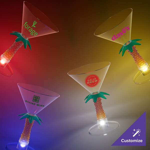 Three customizable plastic palm tree stem martini glasses with blue LED lights on a table.