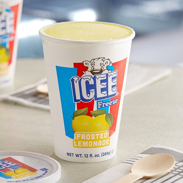 A close up of a ICEE Frosted Lemonade Freeze cup with a wooden spoon on a table.