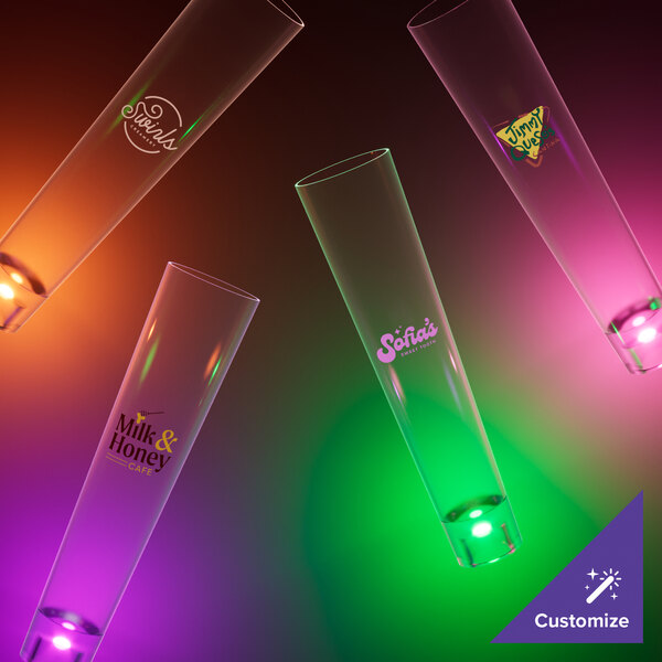 A group of customizable plastic champagne shooters with pink LED lights.
