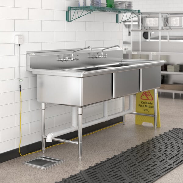 A stainless steel sink with a VersaTile WiFi flood sensor installed.