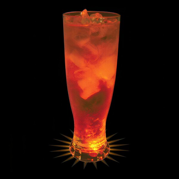 A close up of a 22 oz. plastic pilsner cup filled with orange liquid and ice with an orange LED light inside.